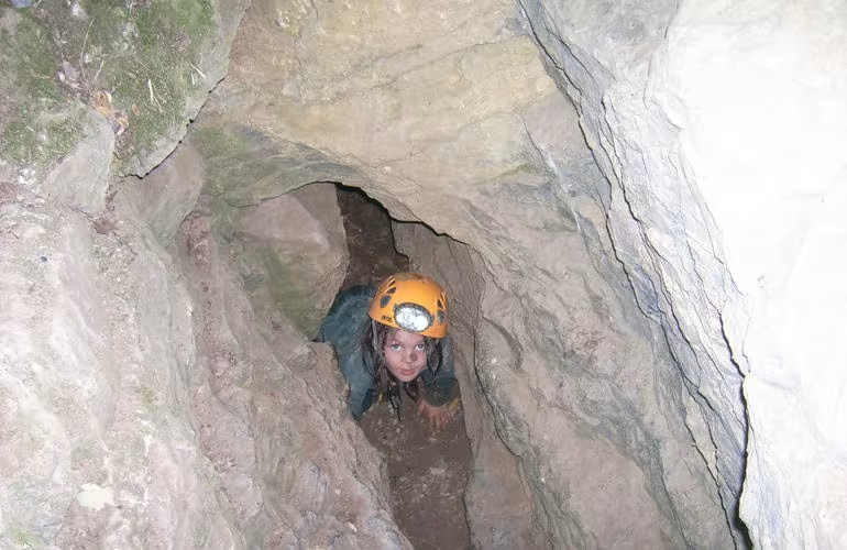 Enfant en train de faire de la spéléologie dans la Grotte des Jeunes en Ardèche